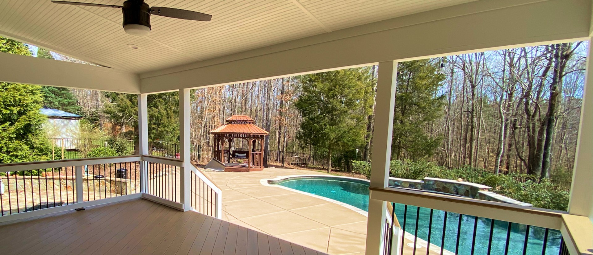 view of a paved backyard, pergola, and pool from deck