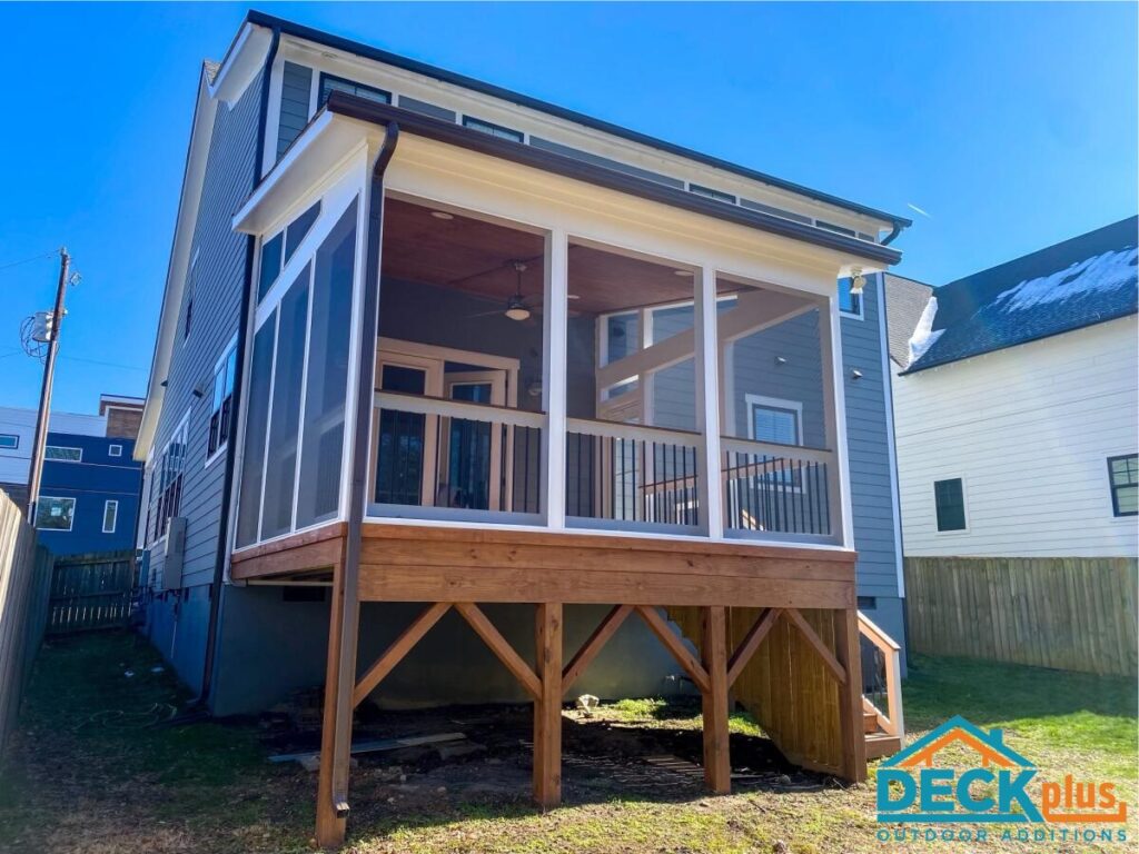 A screened-in porched added on to the back of a blue two-story home.