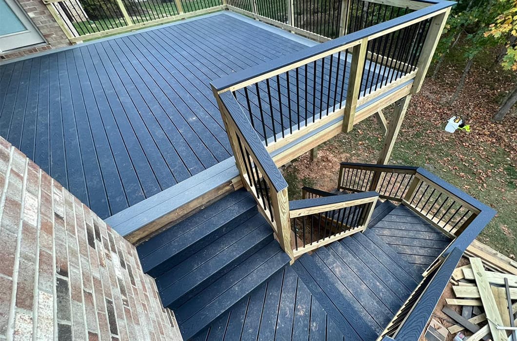 a dark wooden deck with railings and stairs