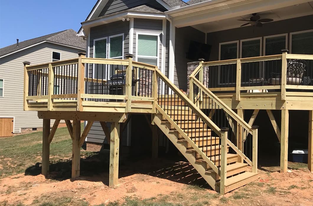 A raised wooden deck with a grill