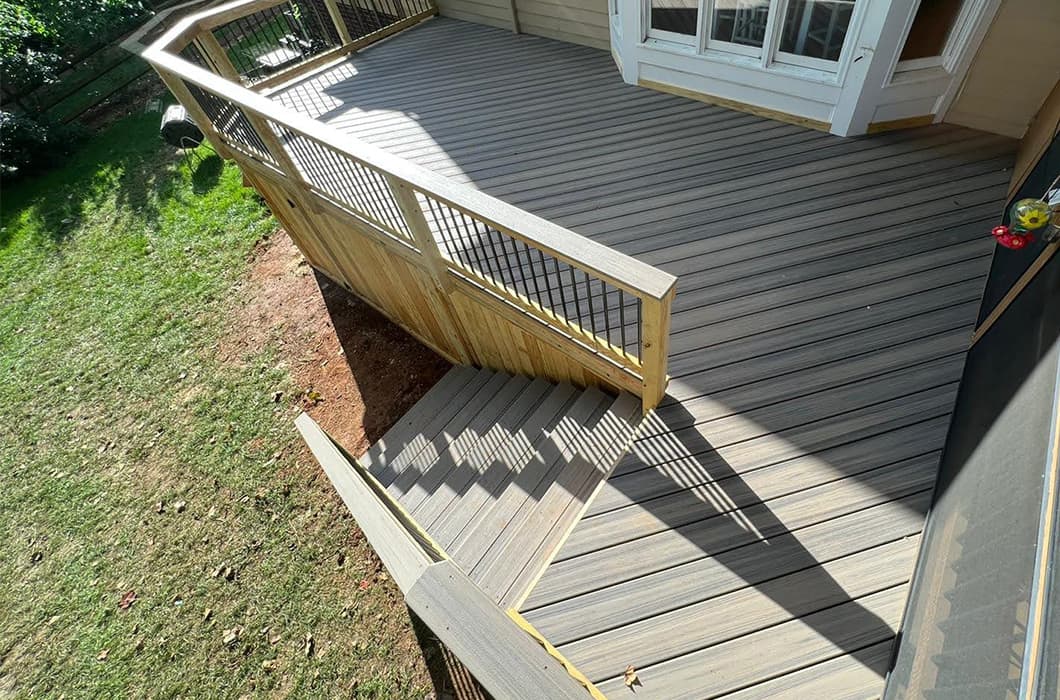 a house with a wooden deck and stairs leading up to the back door