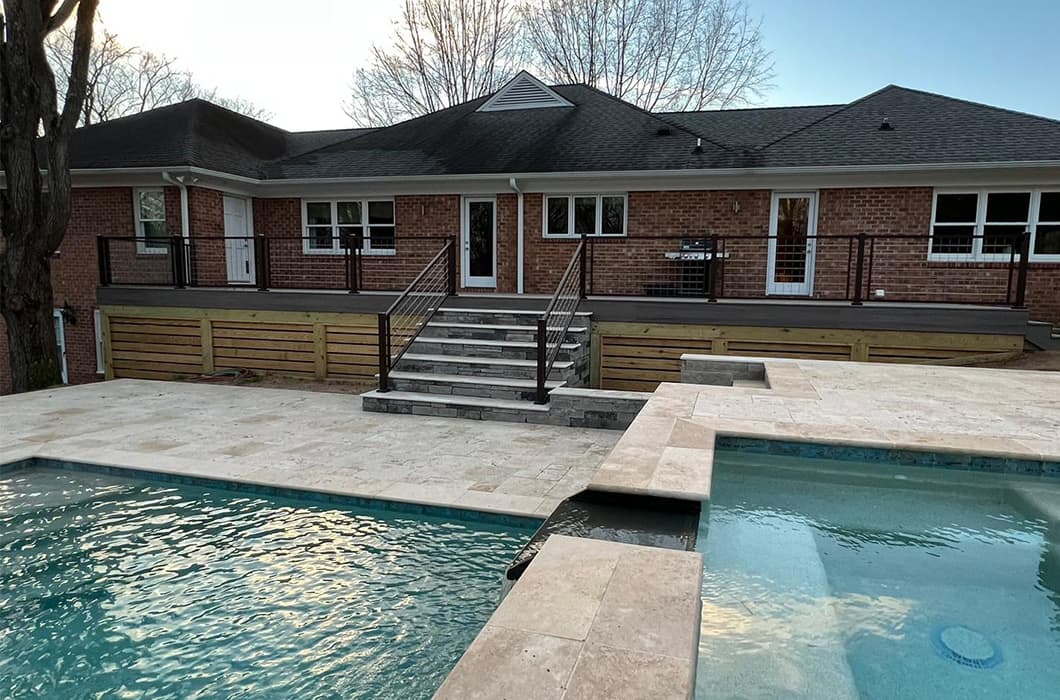 A pool and deck with a brick patio and steps