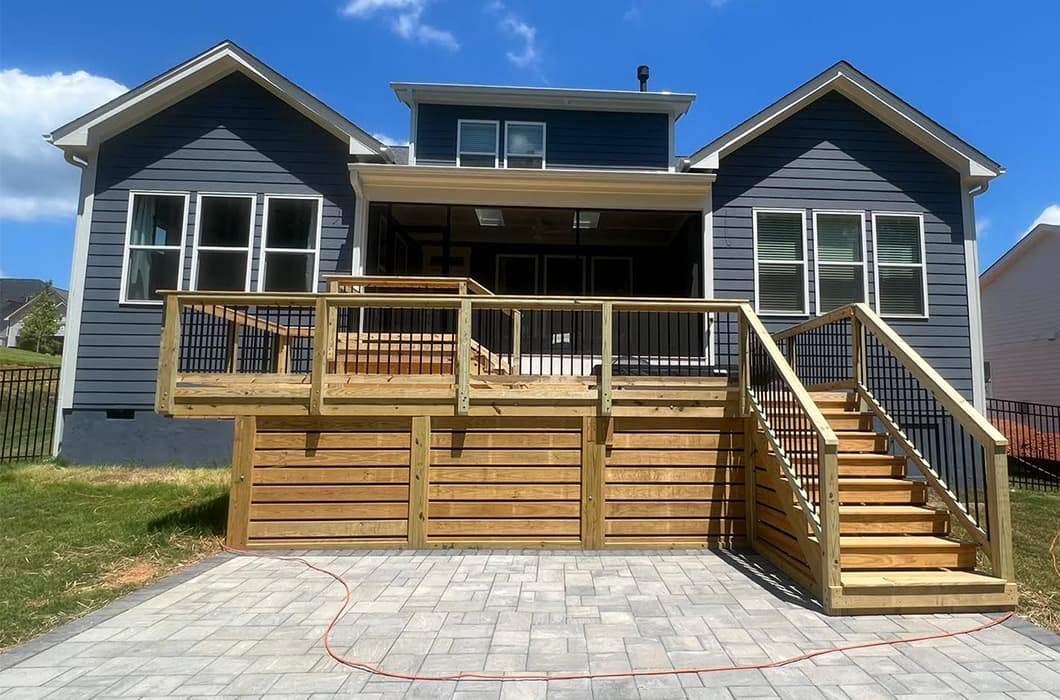 a house with a wooden deck and stone patio