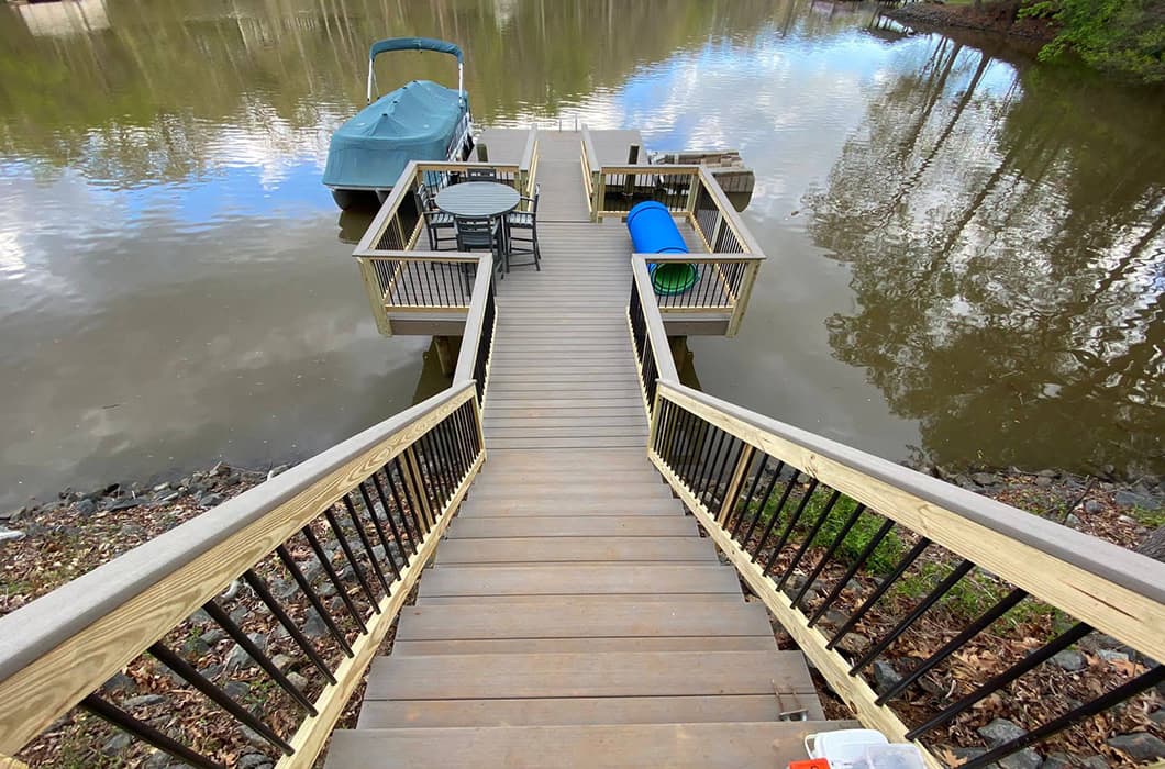 A wooden deck with stairs down to a dock
