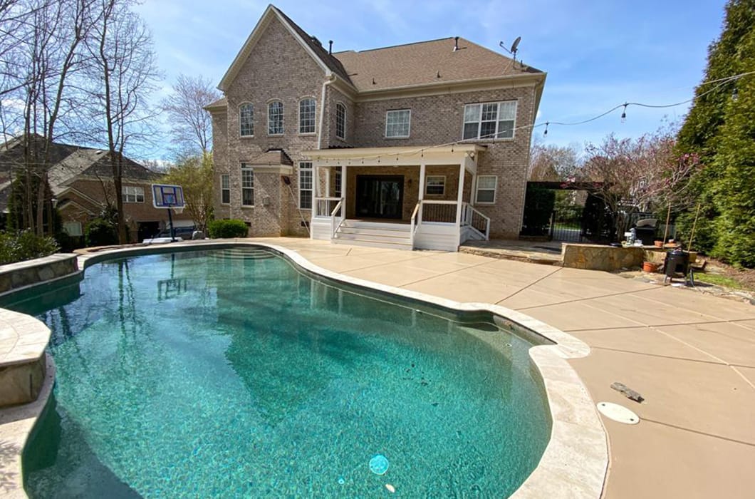 pavement patio with a large pool