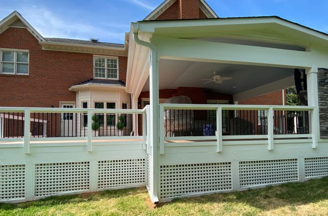 a white covered patio in front of a brick house