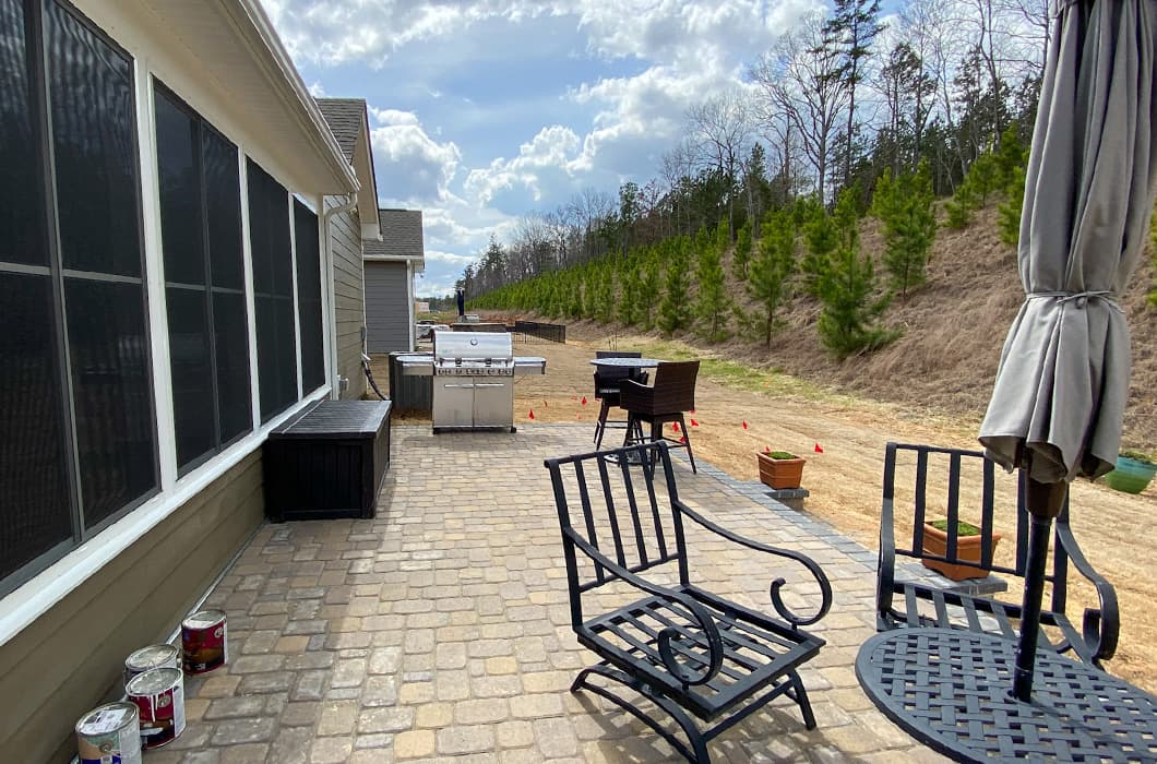 A paver patio with a grill and seating area