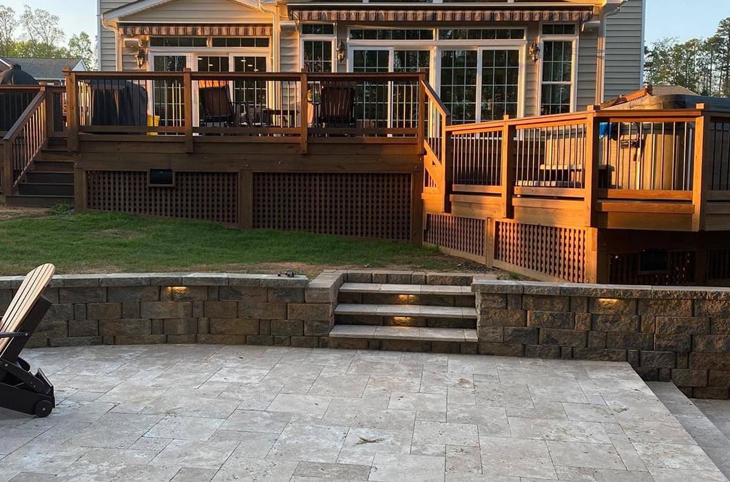 a stone patio with steps leading up to a deck