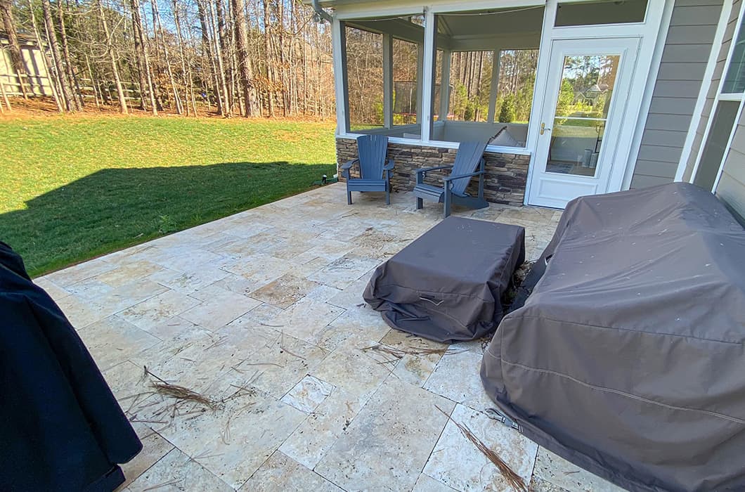 A light stone patio with adirondack chairs