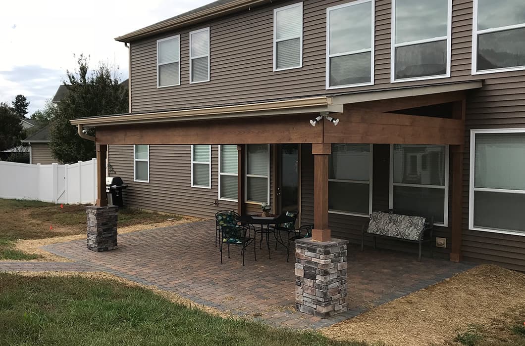 a house with a covered brick patio and pathway