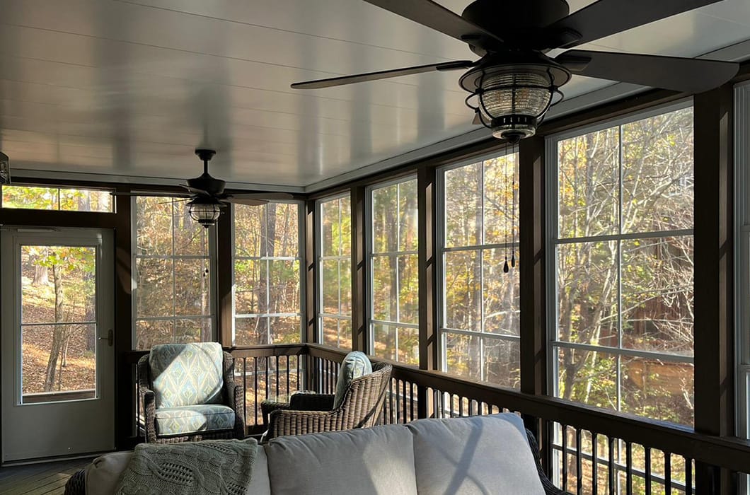a three-season room with furniture and a ceiling fan