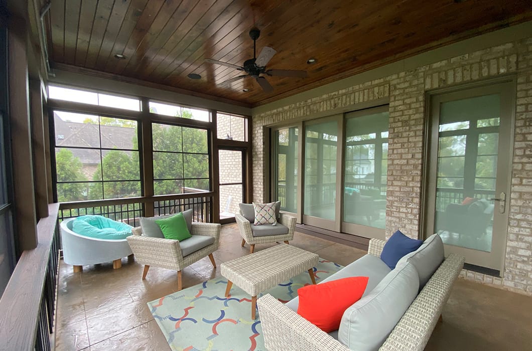 a three-season room with tile flooring and a ceiling fan