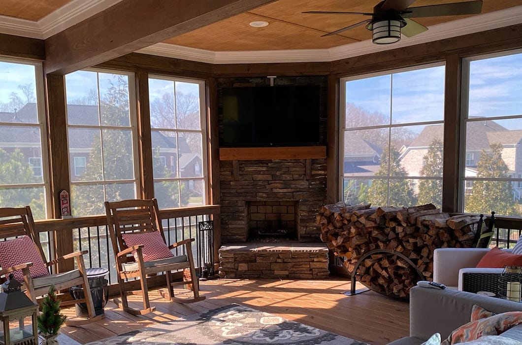 three-season room with a built-in fireplace and mounted tv