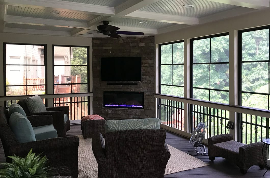 three-season room with a fireplace and coffered ceiling
