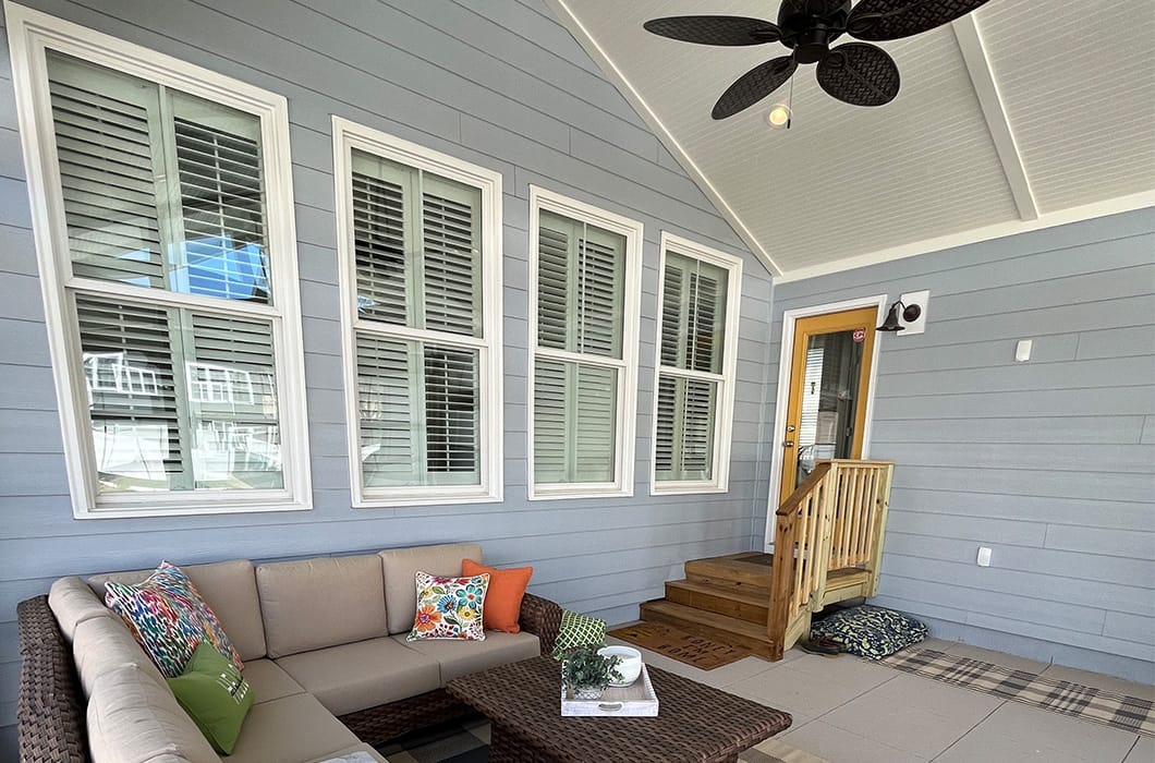 A tile patio with a ceiling fan and wooden steps