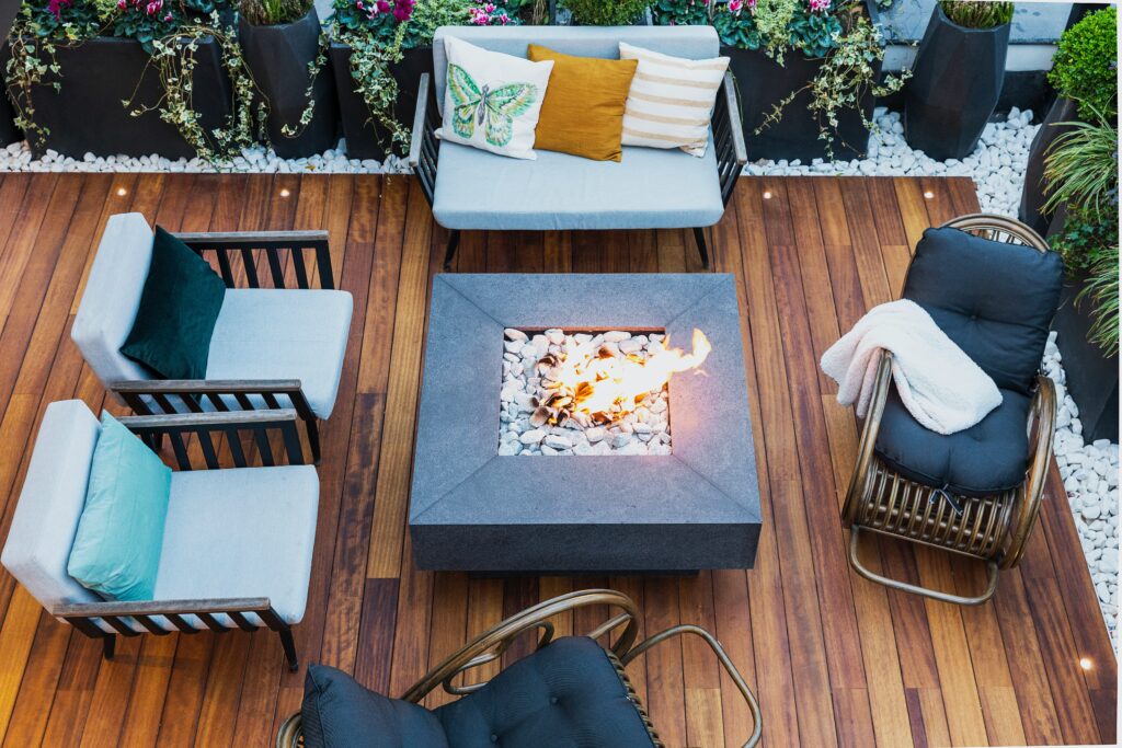 Aerial view of a custom square fire pit on a wooden patio surrounded by outdoor seating.