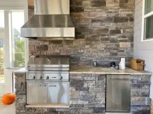 an outdoor kitchen with a grill and sink